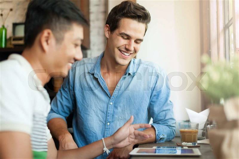 Two Men Using Tablet Computer Internet, Asian Mix Race Friends Guys Sitting at Cafe Natural Light, stock photo