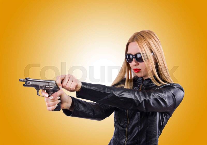 Woman in leather suit with handgun, stock photo