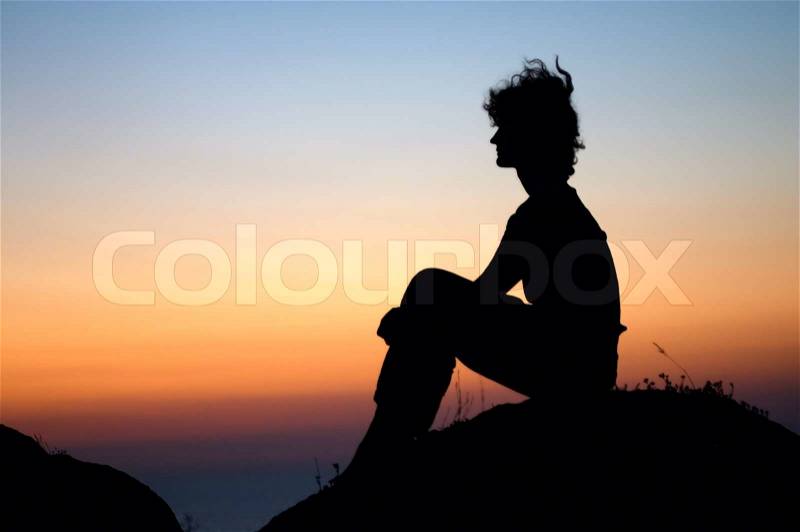 Girl looking for sunset on the top of stone, stock photo