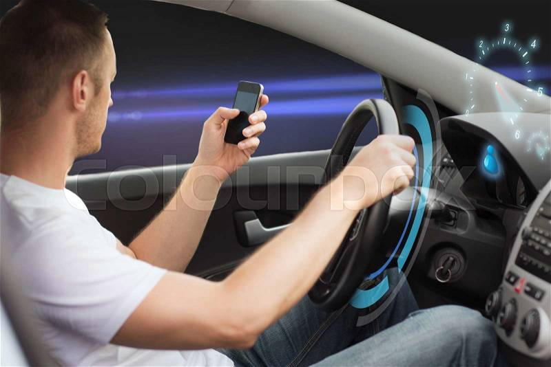 Technology, distraction and driving concept - man looking to smart phone while driving car over dark background, stock photo