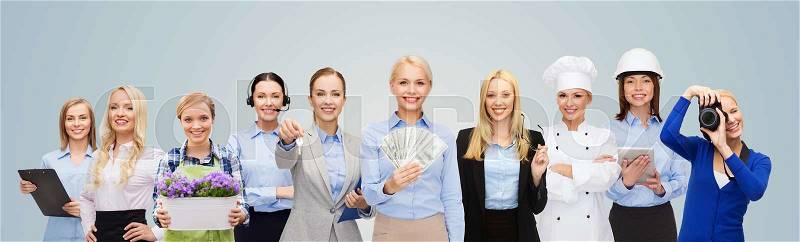 People, profession, employment, compensation and finances concept - happy businesswoman holding dollar money with group of professional workers over blue background, stock photo