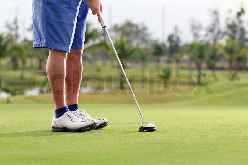 Golf player putting on the green, stock photo