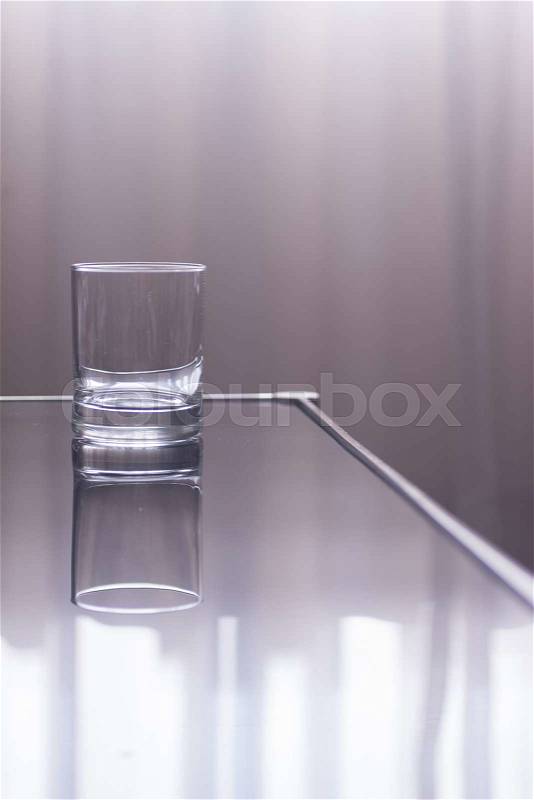 Glass of water on table in window light effect photo, stock photo