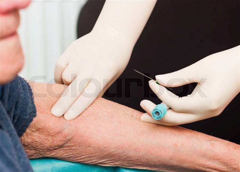 Doctor searching for elderly patient\'s vein for taking blood for lab tests, stock photo