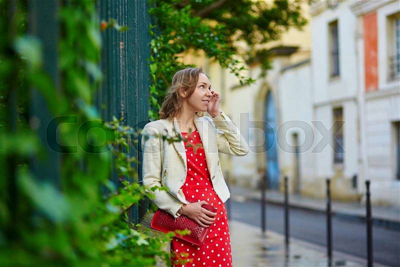 Beautiful young woman in red polka dot dress in Marais, Paris, France, stock photo