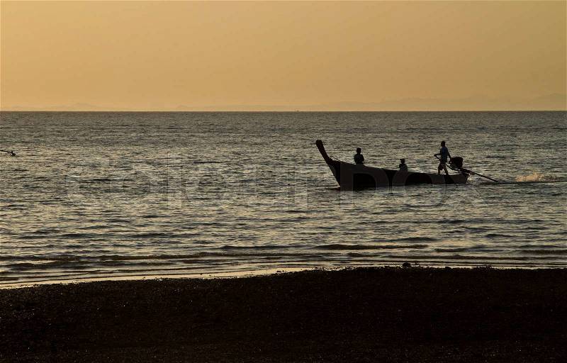 Silhouette of Long tail boat in Railay Beach Thailand at sunset, stock photo