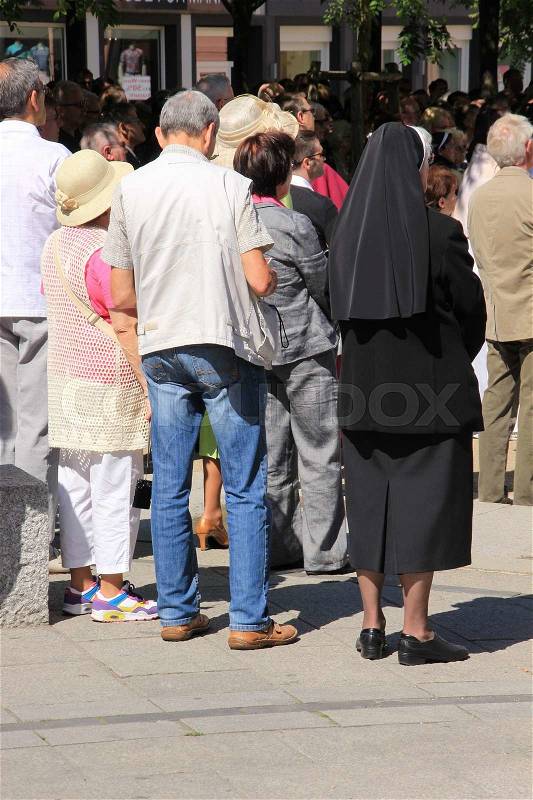 People and a nun in the streets of Trier in Germany, stock photo