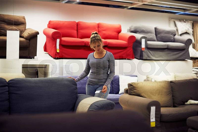 Young hispanic woman shopping for furniture, sofa and home decor in store, stock photo