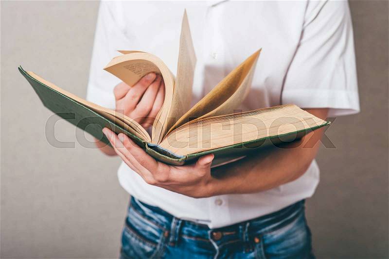 Man in glasses reading a big book, stock photo
