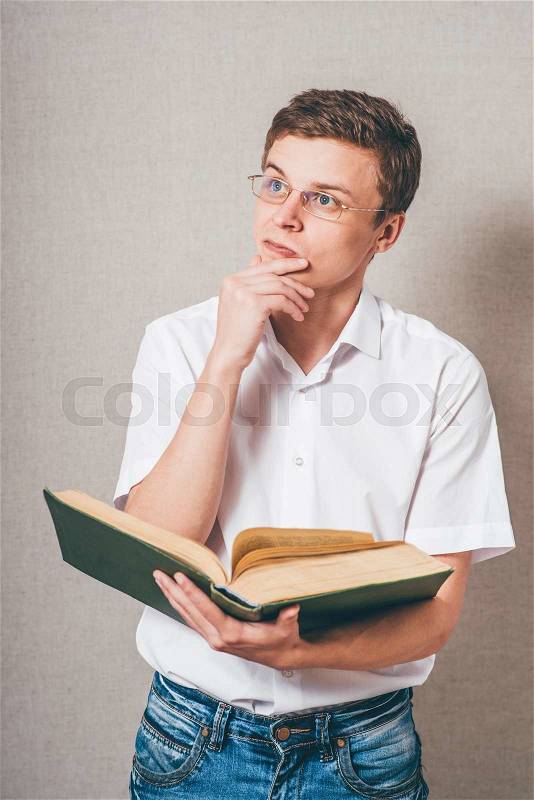 Man in glasses reading a big book, stock photo