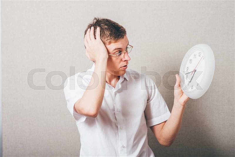 Afraid man with glasses looks at the clock, stock photo
