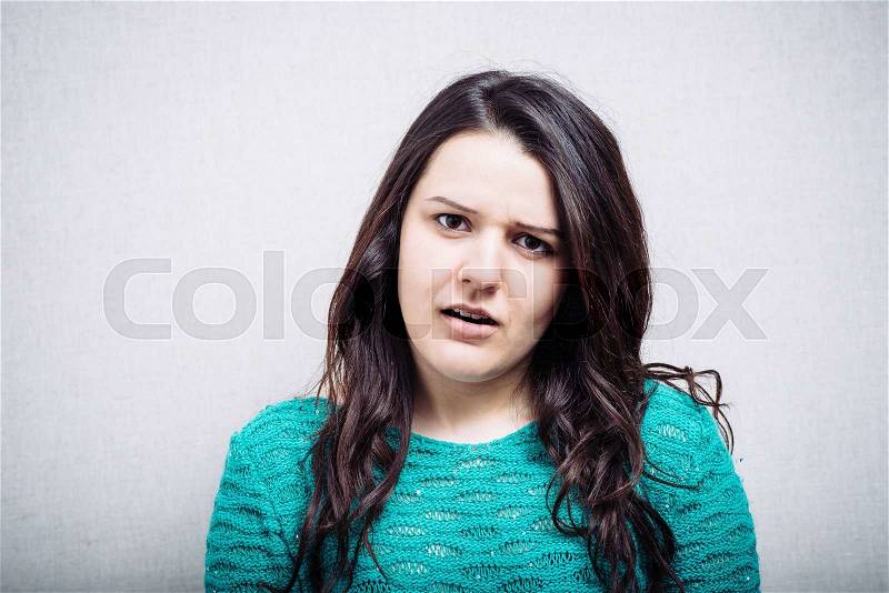 Portrait of a cute brunette girl is offended, stock photo