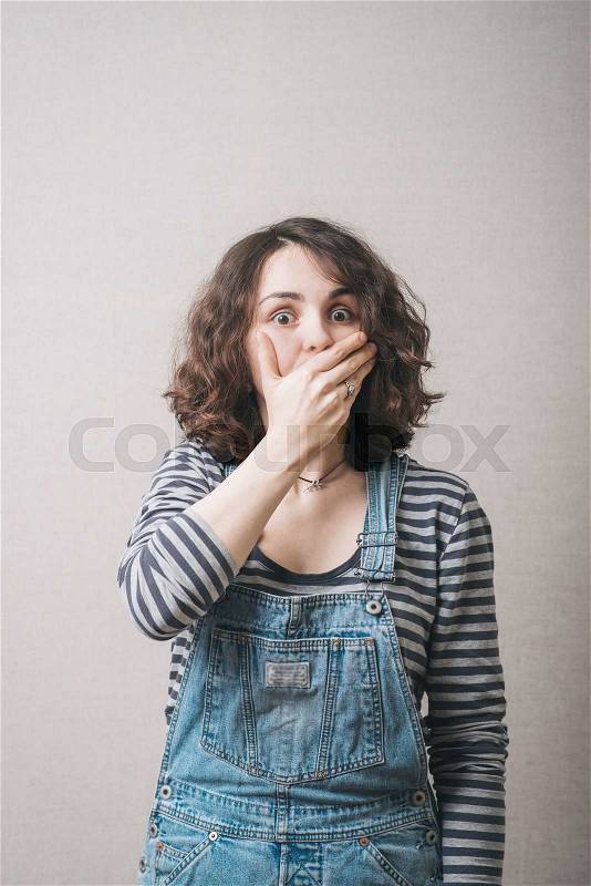Woman surprised and covers her mouth with his hand, dressed in a suit, stock photo