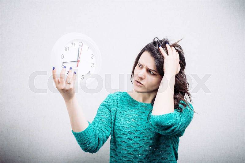 Shocked woman holding office clock, stock photo