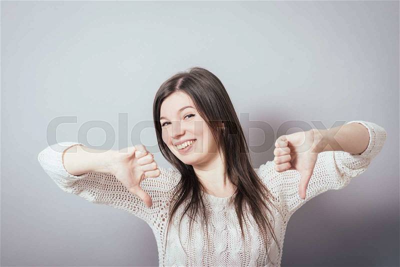 Girl showing thumbs down, stock photo