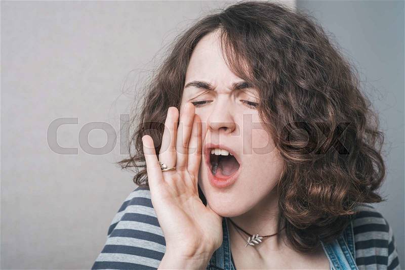 Girl calling someone dressed in overalls, stock photo
