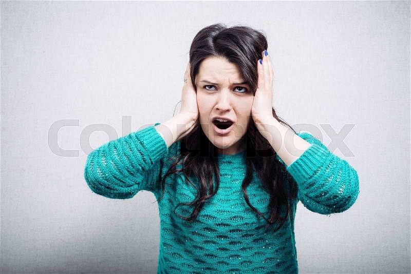 Young woman with its hands covering his ears not to hear noise, stock photo
