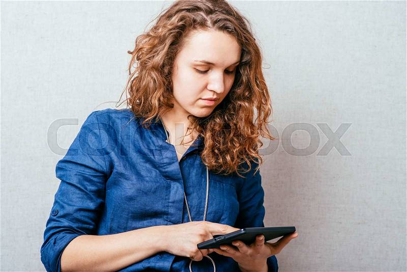 Girl looks in a mobile tablet, stock photo