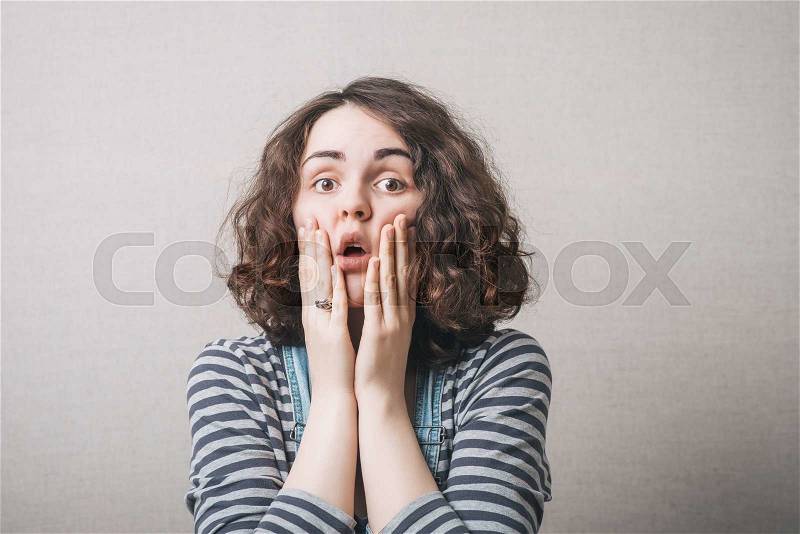 The woman thought, sad, thinking, emotions, fear. On a gray background, stock photo