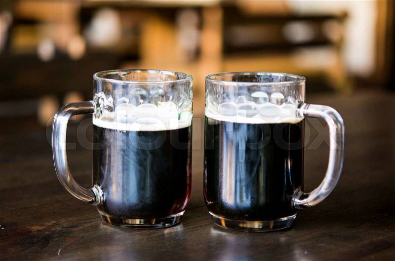 Dark beer in glasses on a wooden table, stock photo