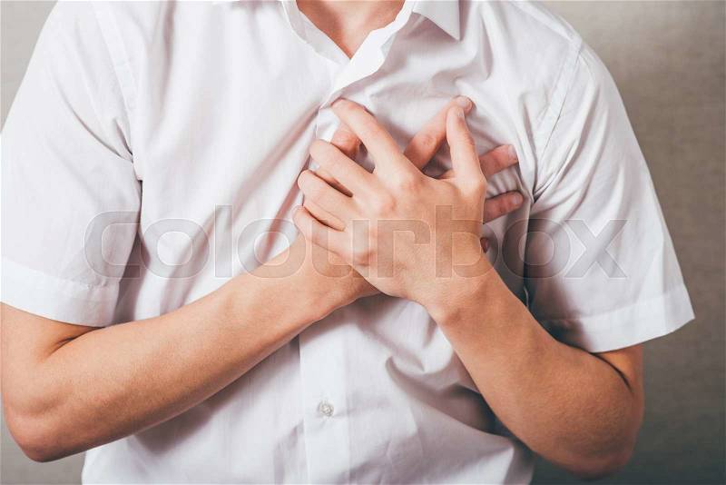 The man put his hands on his chest, the heart. On a gray background, stock photo