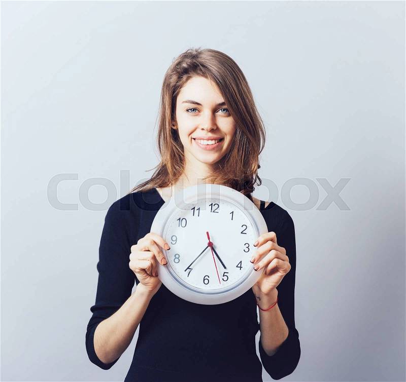 Beautiful smiling woman holding big clock, stock photo
