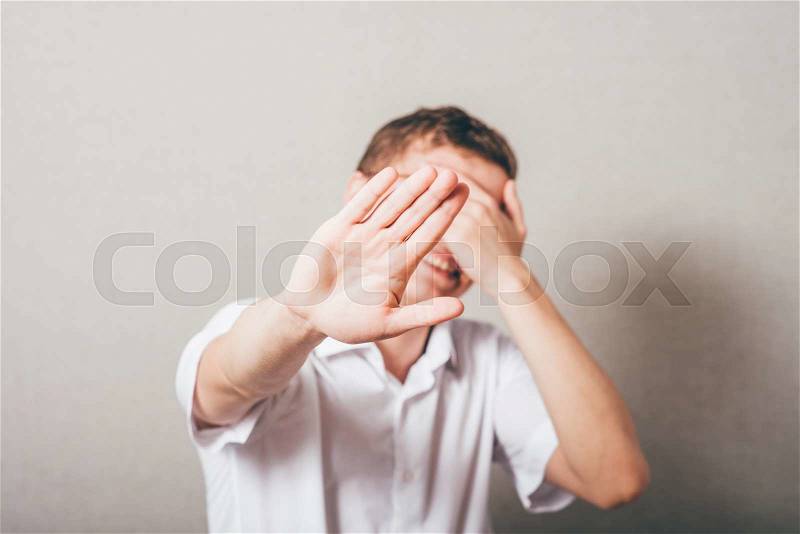 Innocent Man showing stop. one hand showing the stop, the other closes his eyes, stock photo