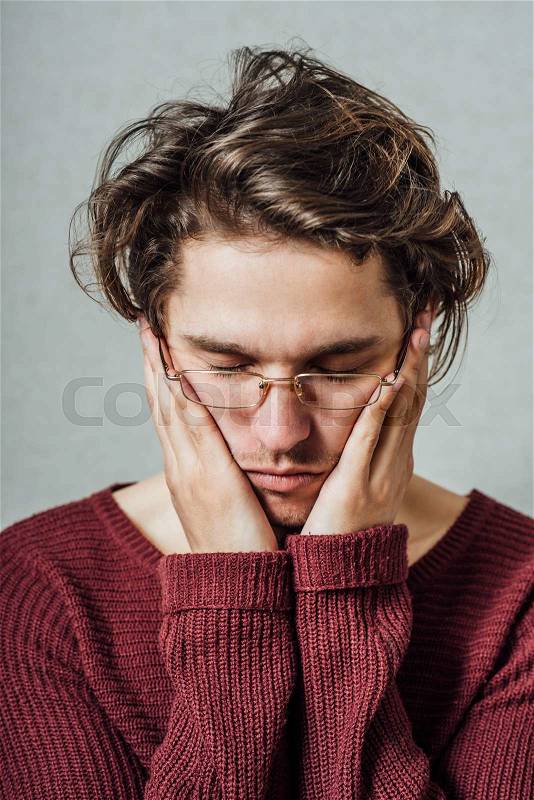 Young businessman holding head in his hands, stock photo