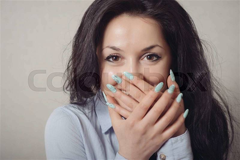 Excited woman happy smile cover her mouth by hand palm young attractive girl portrait, looking at camera smiling isolated over gray background, stock photo