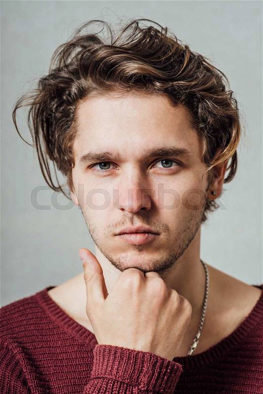 Thoughtful man holding his hand under his chin, stock photo