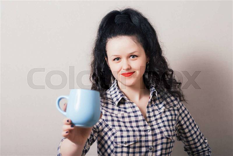 Beautiful young woman with cup of coffee, isolated on a gray background, stock photo