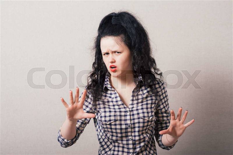 Closeup portrait of young annoyed woman with bad attitude, giving talk to hand gesture with palm outward. Negative human emotion, facial expression feeling, body language, stock photo