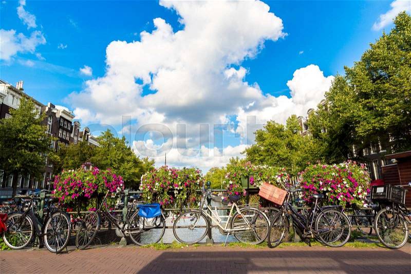 Bicycles on a bridge over the canals of Amsterdam. Amsterdam is the capital and most populous city of the Netherlands, stock photo