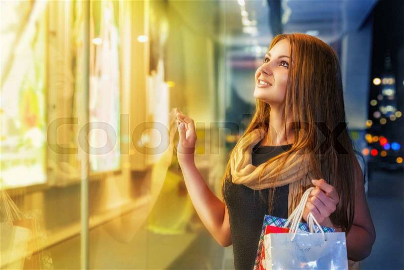 Smiling young woman shopping at an outdoor mall, stock photo