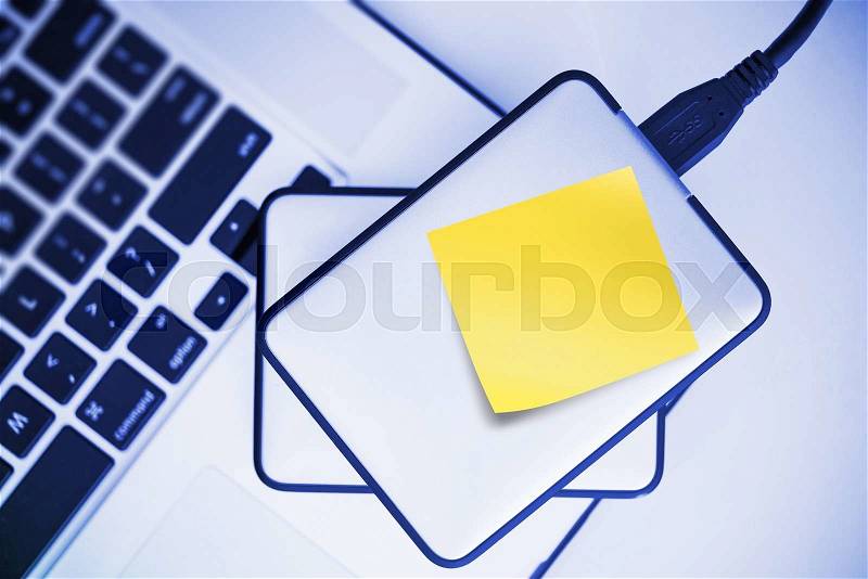 External Hard Drives Backup For Laptop. Small Portable Hard Drive with Yellow Sticky Paper Note. Mobile Workstation, stock photo