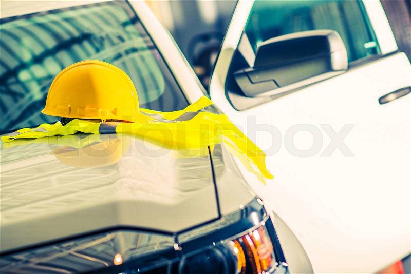 Safety Equipment and High-Visibility Safety Vest at Construction Work. Yellow Helmet and Bright Yellow Jacket, stock photo