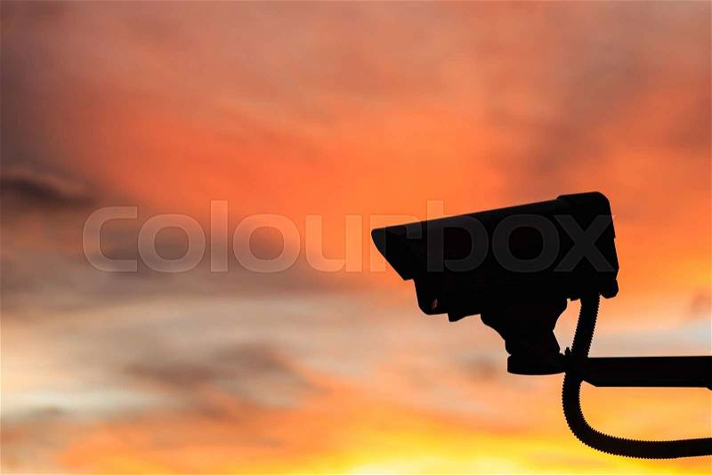 Close up Silhouette Security CCTV camera with beautiful sunset background, stock photo