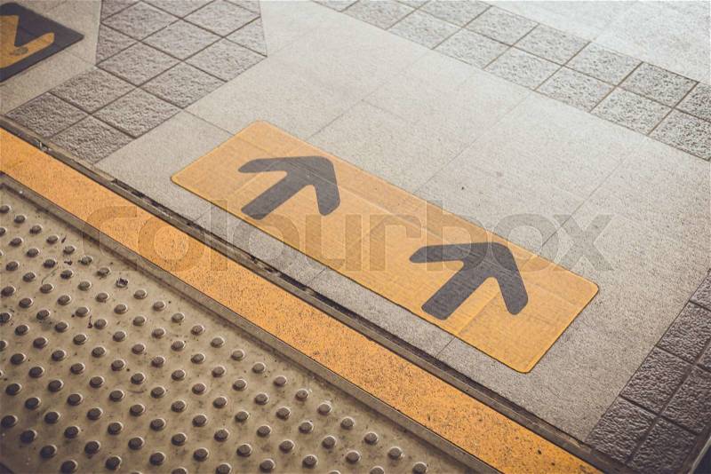 Close up Arrow sign on floor at the sky train station, bangkok, Thailand, stock photo