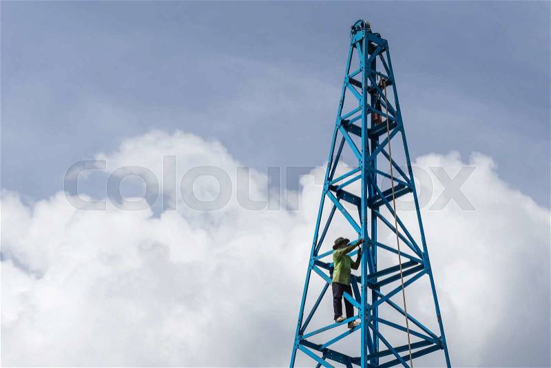Thai worker working on the blue construction crane with blue sky background, stock photo