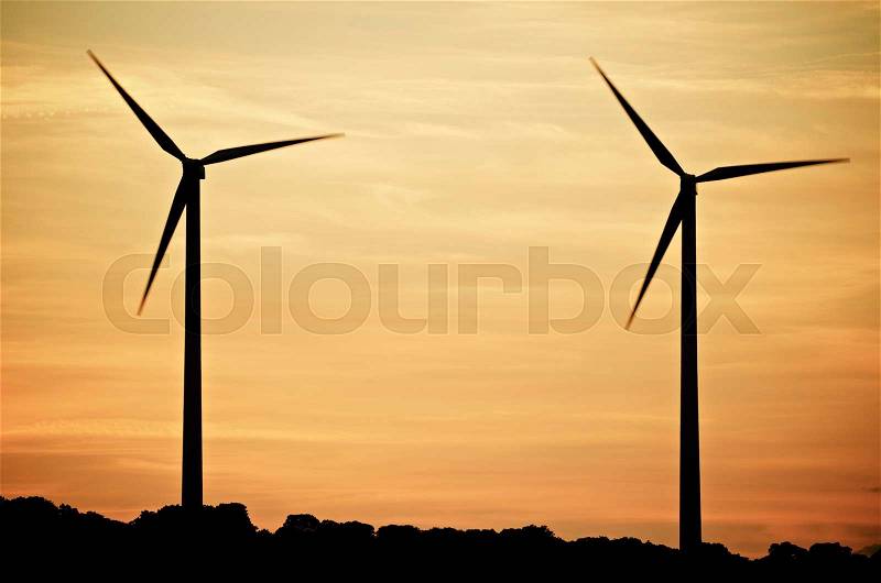 Aligned windmills for renowable electric production at sunset, Zaragoza province, Spain, stock photo