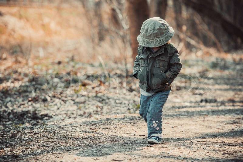 Funny little child walking in the woods, photo in vintage style, stock photo