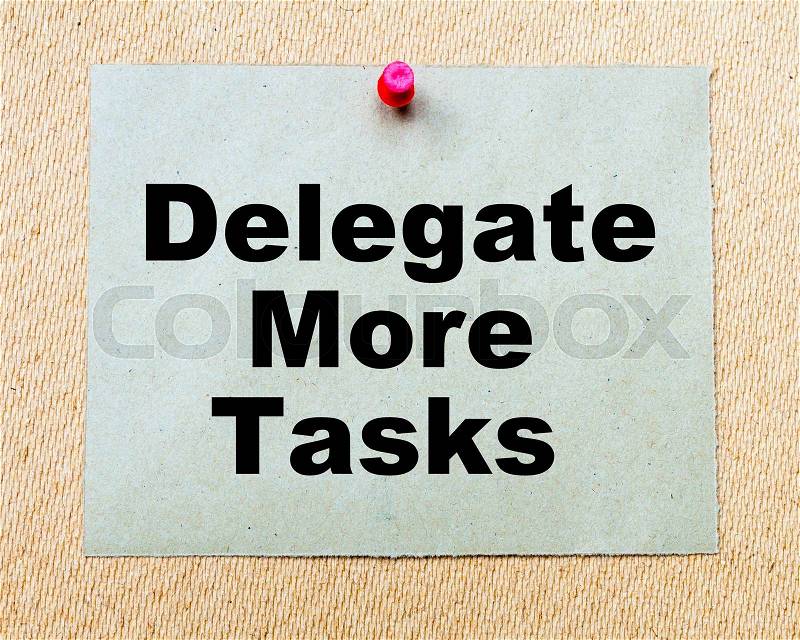 Delegate More Tasks written on paper note pinned with red thumbtack on wooden board. Business conceptual Image, stock photo