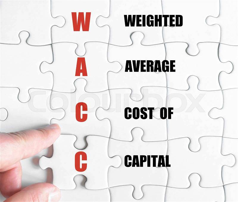 Hand of a business man completing the puzzle with the last missing piece.Concept image of Business Acronym WACC as Weighted Average Cost Of Capital, stock photo
