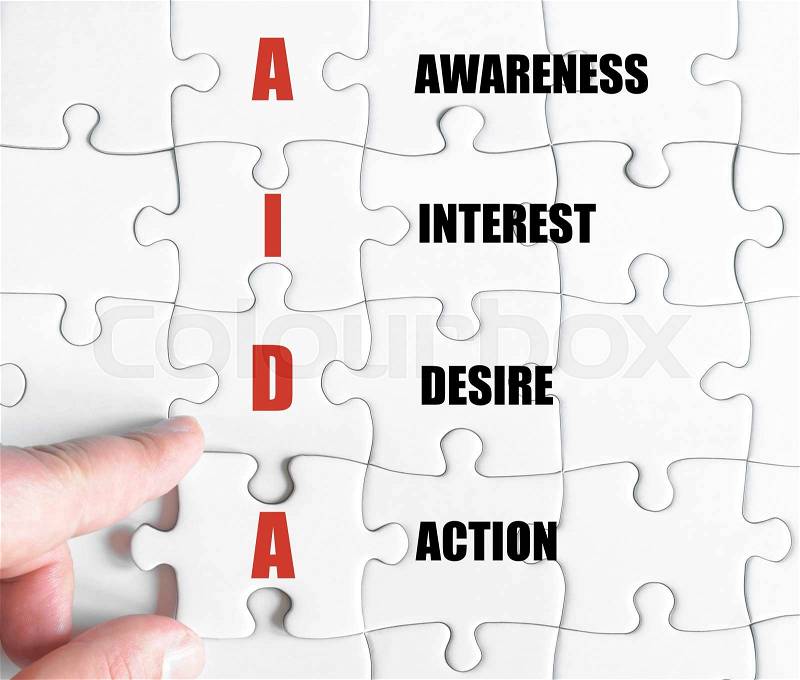 Hand of a business man completing the puzzle with the last missing piece.Concept image of Business Acronym AIDA as Awareness Interest Desire Action, stock photo