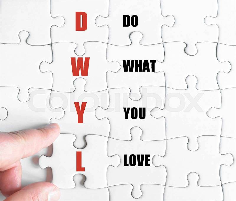 Hand of a business man completing the puzzle with the last missing piece.Concept image of Business Acronym DWYL as Do What You Love, stock photo
