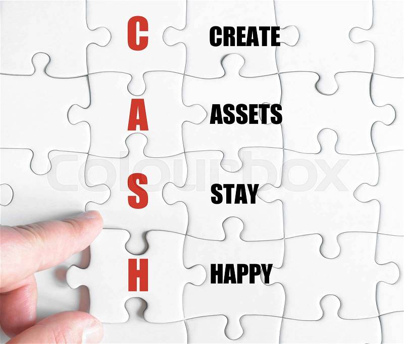 Hand of a business man completing the puzzle with the last missing piece.Concept image of Business Acronym CASH as Create Assets Stay Happy, stock photo