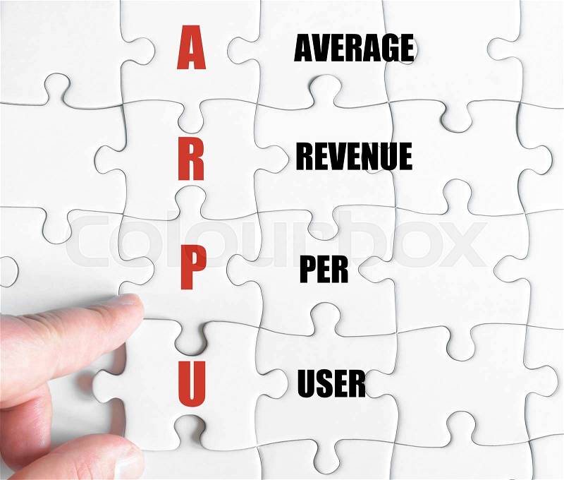 Hand of a business man completing the puzzle with the last missing piece.Concept image of Business Acronym ARPU as Average Revenue Per User, stock photo