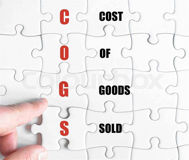 Hand of a business man completing the puzzle with the last missing piece.Concept image of Business Acronym COGS as Cost Of Goods Sold, stock photo