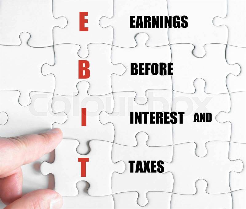 Hand of a business man completing the puzzle with the last missing piece.Concept image of Business Acronym EBIT as Earnings Before Interest And Taxes, stock photo