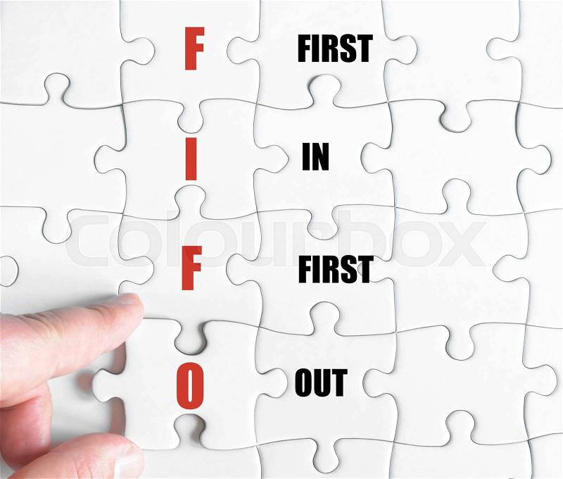 Hand of a business man completing the puzzle with the last missing piece.Concept image of Business Acronym FIFO as First In First Out, stock photo